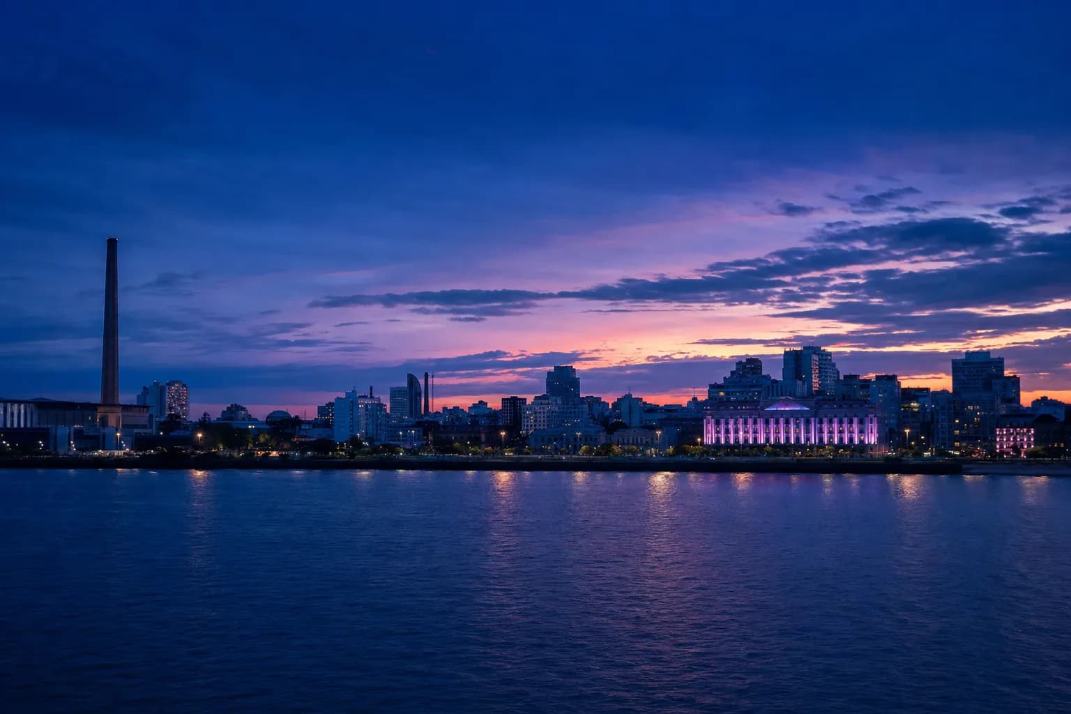 Vista do pôr do sol na orla do Guaíba com o horizonte de Porto Alegre ao fundo