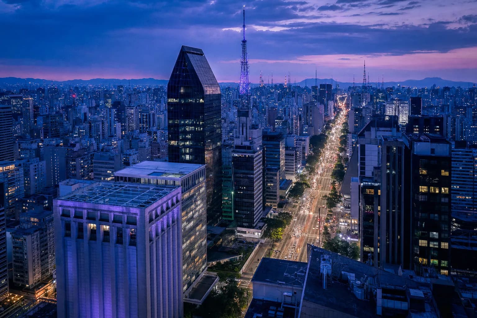 Vista aérea da Avenida Paulista ao entardecer, com os prédios da Faria Lima ao fundo
