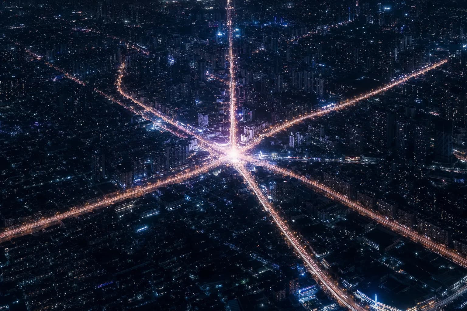 Vista aérea noturna de uma cidade com ruas brilhando como uma rede de rastros de luz convergindo para um nó